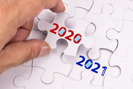 Concept of finger flipping puzzle transiting from 2020 to 2021 new year with mask and vaccine...