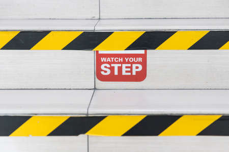 Watch Your Step word signage with yellow black strip on stair stepsの写真素材