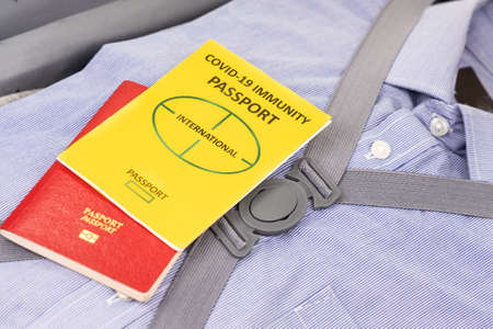 Concept of covid-19 Immunity Passport for international travel with clothes packed in luggage bag...
