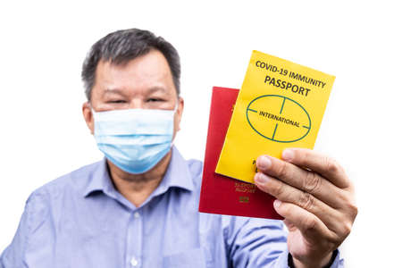 Asian man holding the conceptual Covid-19 Immunity Passport document ready to travel, with focus on documentsの写真素材