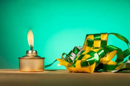 Conceptual traditional Malay oil lamp named pelita with decorative ketupat for Hari Raya Aidilfitri...