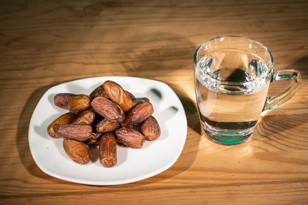 Muslim iftar of breaking of fast during Ramadan month with preserved sweet dates and waterの写真素材