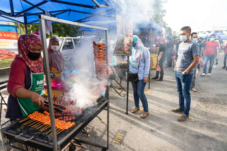KUALA LUMPUR, MALAYSIA, April 16, 2021: Muslim queing to buy food from street bazaar for iftar or breaking of fast, with observance of social distance and face mask.のeditorial素材