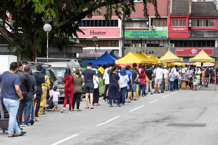 KUALA LUMPUR, MALAYSIA, April 16, 2021: Shoppers queing in line to enter street bazaar with crowd...