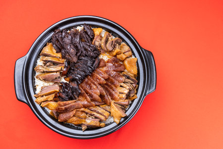 Overhead view of Lap Mei Fan or waxed meat rice with red on red background. It is Chinese traditional dish that is served during Chinese New Year festive celebrationの写真素材