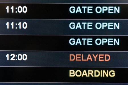 Close-up on airport terminal flight information digital board with focus on word Delayed, Gate Open, Boardingの写真素材