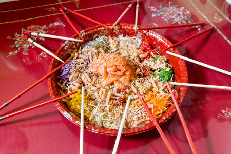 Serving of yusheng or yee sang with raw salmon belly during Chinese New Year with chop sticks laid around plate, believed to bring good luck and prosperityの写真素材