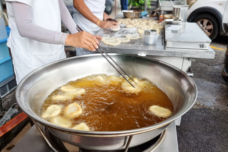 Hawker deep frying the Ham Chim Peng in wok with hot oil, a popular and delicious Chinese street...