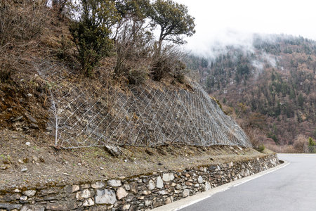 Wire mesh grid installed on slope to stabalize the soil and minimize landslide risk in Sichuan, Chinaの写真素材