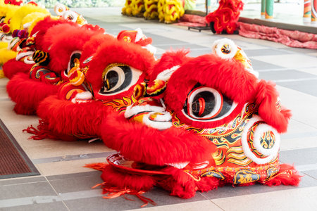 Red lion head costume for traditional Chinese Lion dance laid in a row, ready for performanceの写真素材