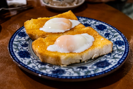 Roti bakar telur goyang or toast bread with half boiled eggs, popular breakfast delicacy in Ipoh,...