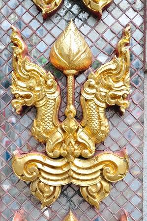 Golden naga head on decorated mirror pattern.   It is decoration on Thai temple wall.の写真素材