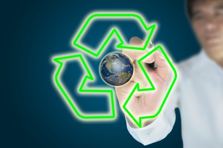 Hand of business man or male write recycle symbol with earth globeの写真素材