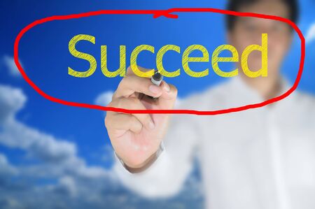 Business man write succeed on touch screenの写真素材