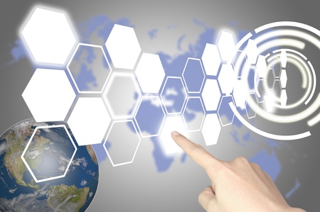 Hand of business man press hexagon button on world map or tablet pc touch screenの写真素材