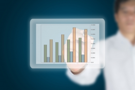 Hand of business man write a business graph on tablet pc touch screenの写真素材