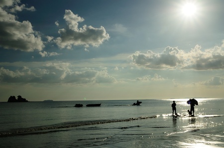 Silhouetted family playing at the beach of Mae pim capeの写真素材