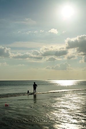 Silhouetted of father and son on the beach of Mae pim capeの写真素材