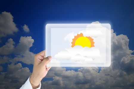 Hand holding tablet pc with image of the sun の写真素材