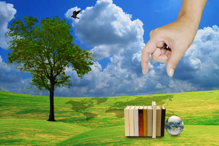 hand pick book with lonely tree and earth globeの写真素材