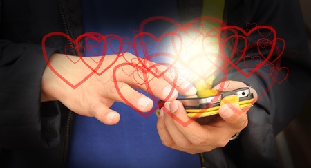 Hand of business man send heart on mobile phone as Valentine conceptの写真素材