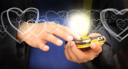 Hand of business man send heart on mobile phone as Valentine conceptの写真素材