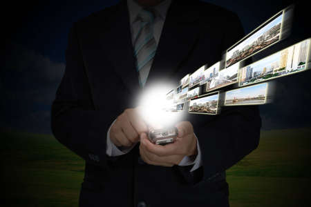 Business Man Hand shows Touch Screen Mobile Phone with Streaming imagesの写真素材