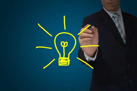 Hand of business man write a light bulb on tablet pc touch screenの写真素材