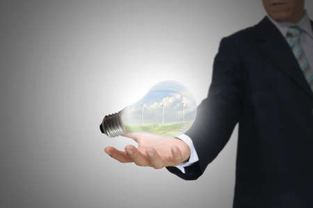 Light bulb in hand business man on grey backgroundの写真素材