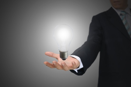 Light bulb in hand business man on grey backgroundの写真素材
