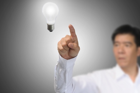 Business Man touch light bulb の写真素材