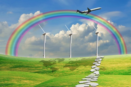 Airplane flying over green field with blue sky and turbine power generatorの写真素材