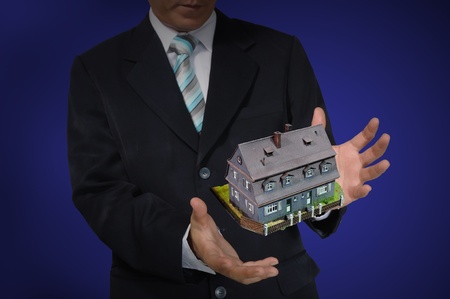 Business Man holding house or homeの写真素材