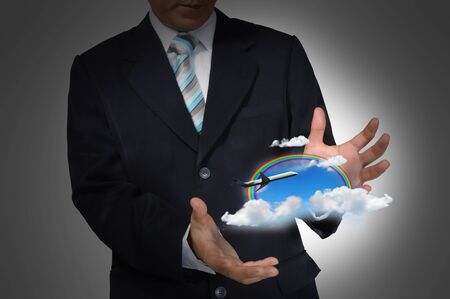 businessman hold plane on blue skyの写真素材