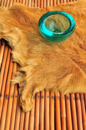 Blue glass ashtray over cow leather and rattan in Bangkok, Thailand の写真素材