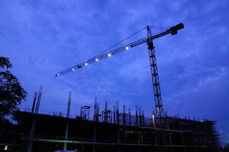 Tower crane beside construction site at twilightの写真素材