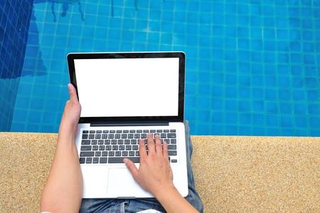 Young Businessman with Computer next to Swimming Poolの写真素材