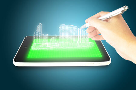 Male hand draw 3D hologram building on Tablet Touch screenの写真素材