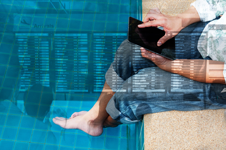 Double Exposure of Man Use Wireless Digital Tablet to Check the Flight Schedule beside the Pool as Mobile Internet Technology Application Concept.の写真素材