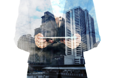 Double exposure of a businessman and a city using a tablet over white background as Business...