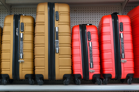 Yellow and Red Suitcases in a Row on Shelf in Supermarket Retail Store outletの写真素材