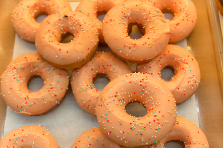 Fresh Donuts with Color Sugar Granules Decorated on shelf. Selective Focus on Big donutの写真素材