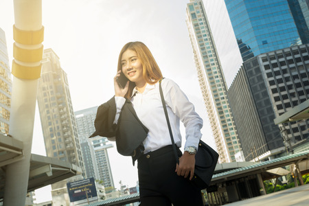 Asian Business Woman use Wireless Smartphone in Modern City as Digital Technology Conceptの写真素材