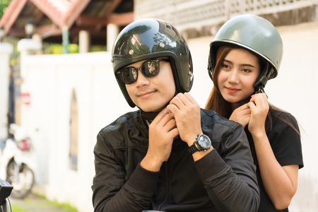 Young Adult Asian Couple, Male and Female Biker or Motorcyclist Wearing Safe Helmet before Travel on Motorcycle as Accident Prevention or Safety Riding Concept.の写真素材