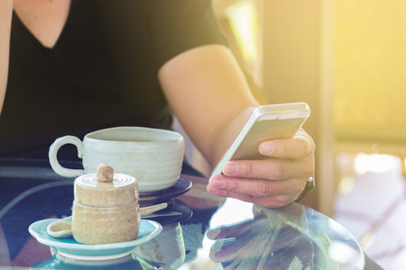 Hand of Businessman or Male use Wireless Smartphone with Cup of Coffee in Coffee shop, Cafe or Restaurant as Technology with Modern Lifestyle Conceptの写真素材