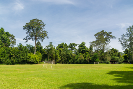 Football or Soccer Field with Goal Pole in the Woods over Mountain of Thailand under Summer Day Blue Sky.の写真素材