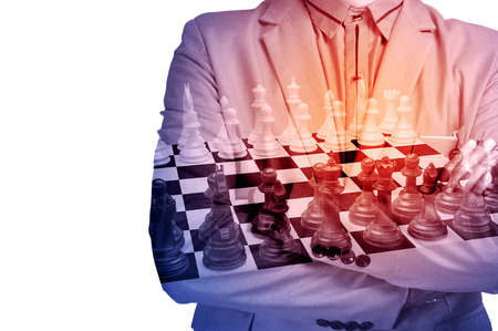 Double Exposure of Businessman in Suit with Chess on Chessboard and Graph as Strategic Planning or Stock Market Investment Strategy Concept for use as Background.の写真素材