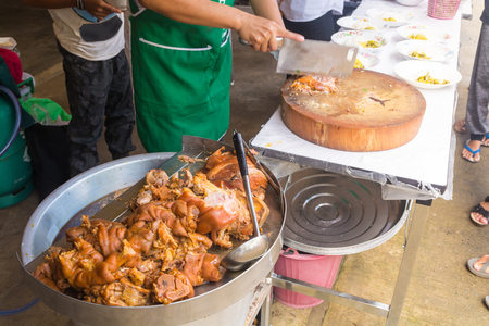 Cooked Stewed pork leg warmed on Aluminium Tray Over Gas Stove ready to Chop and Serve with Rice.  It is popular dish local street food in Thailandの写真素材