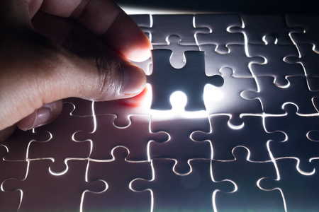 Male or Man Hand and Finger put Piece of Jigsaw in Place to Solve or Match Puzzle as Business Solutionの写真素材