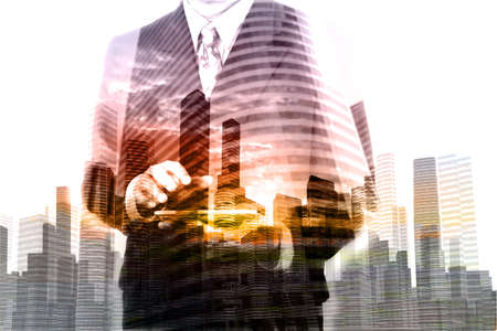 Double Exposure of Businessman hold Digital Wireless Table with City Building and Skyscraper as Concept of Real Estate or Technology business administration.の写真素材